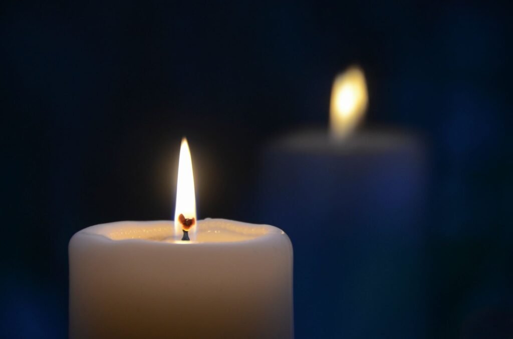 Velas acesas em ambiente sereno, simbolizando memória e conforto no luto